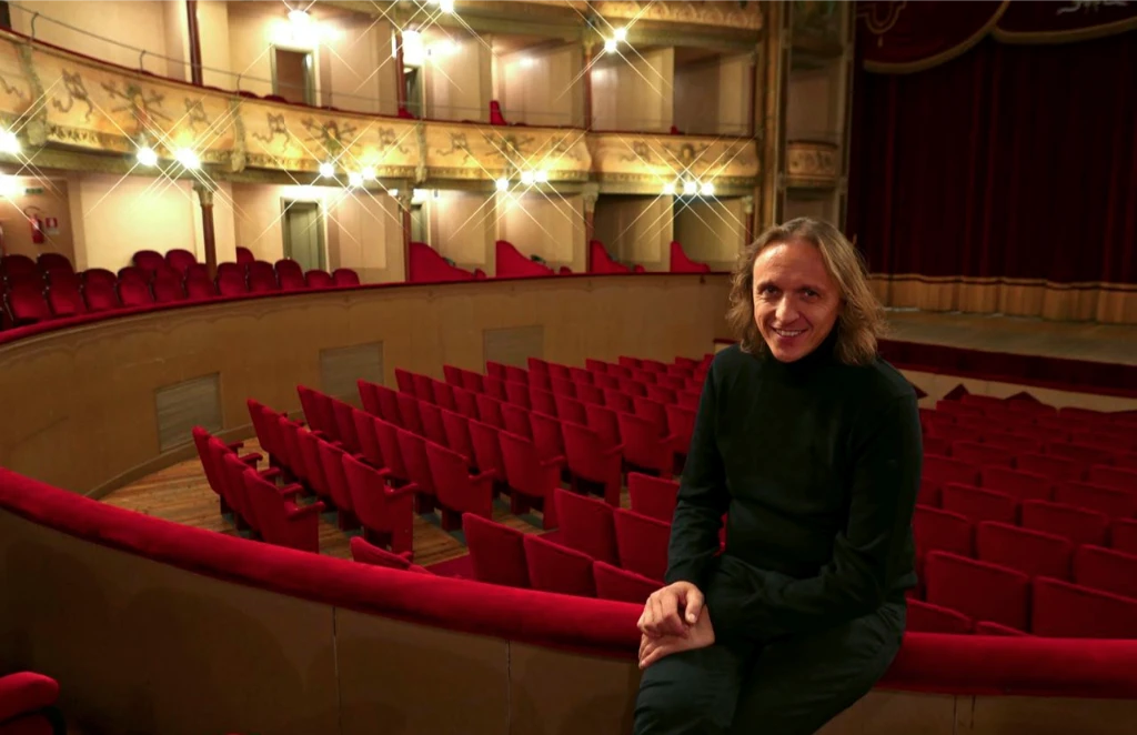 Primo piano su Alessandro Anderloni Direttore artistico del teatro di lonigo sullo sfondo del teatro stesso